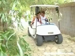 A girl and her sweetheart are driving around in a golf cart. Suddenly they stop and the lad goes ahead to touch the girl up,